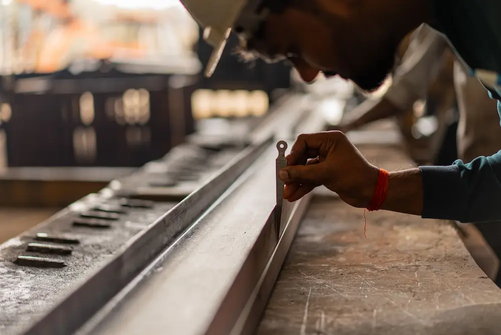 Worker performing a dimensional inspection of a metal component