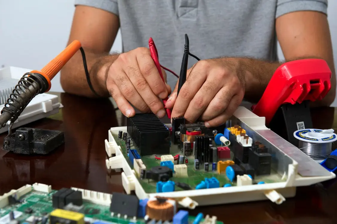 Engineer testing electrical components on a circuit board during practical engineering work
