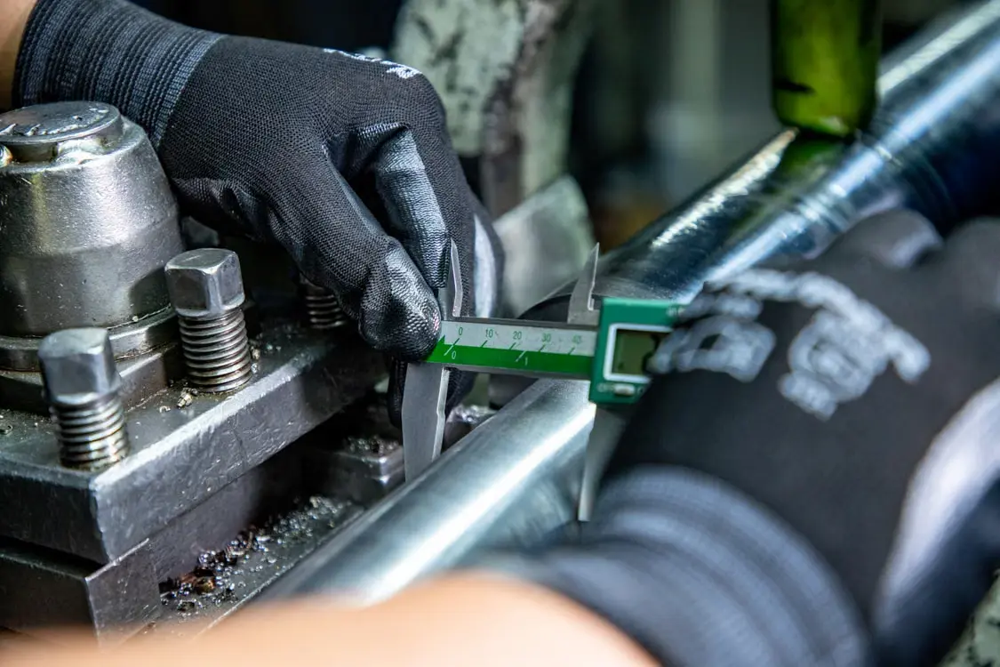 Technician performing precision inspection on a metal component for NDT quality testing