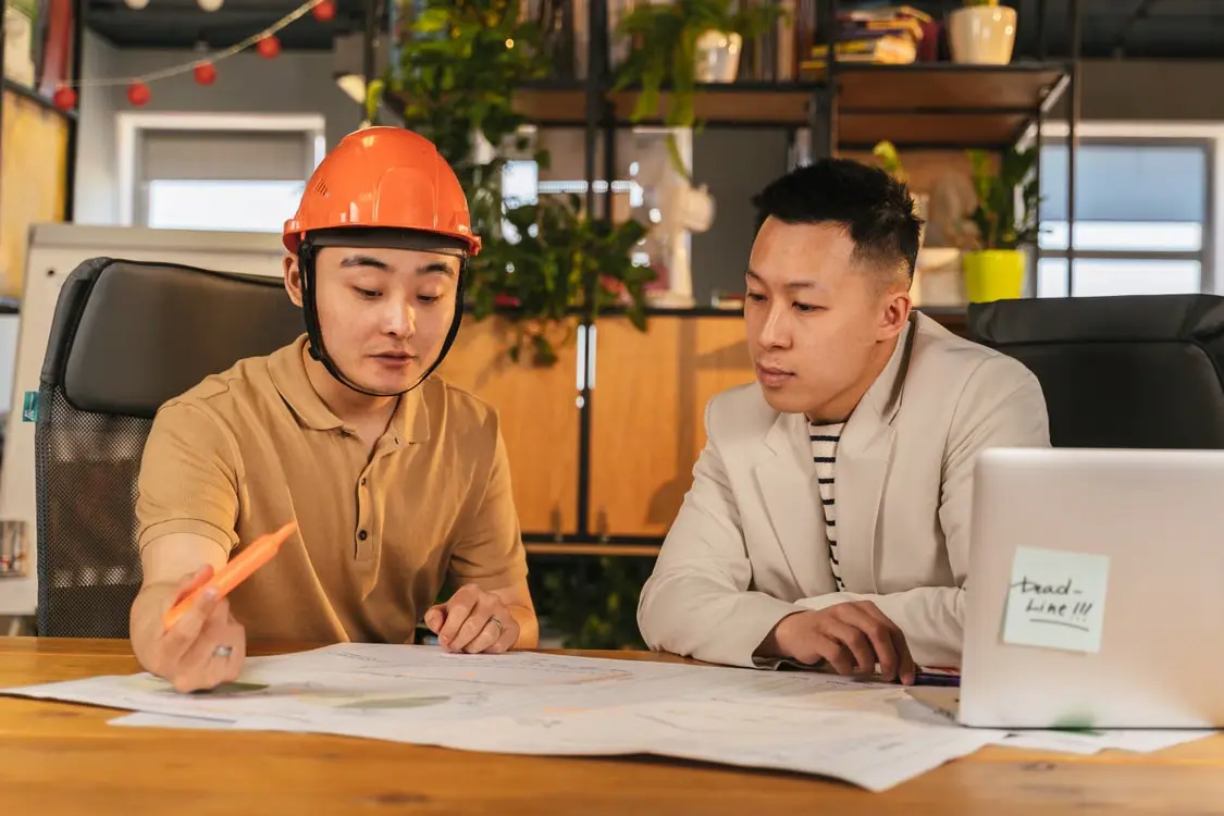 Engineering professionals reviewing technical drawings and project plans at a workplace